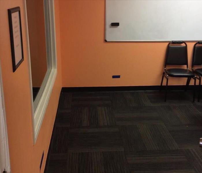 Water saturates the floor of an orange commercial office space