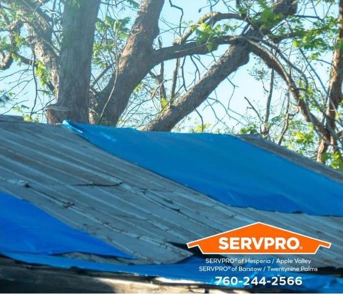 A storm-damaged roof is tarped to prevent secondary damage. 